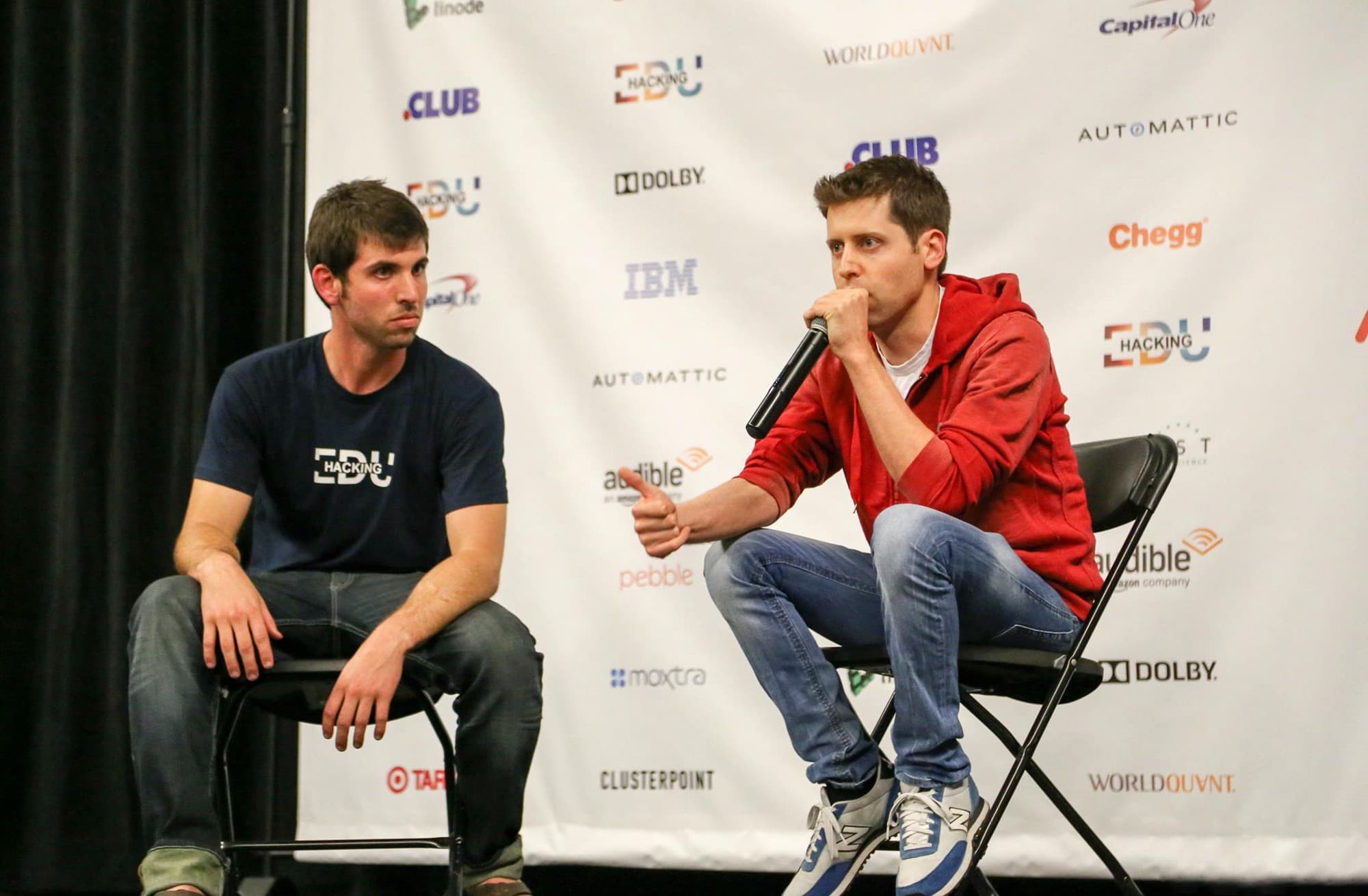 Sam Altman em painel, 2016, segurando microfone