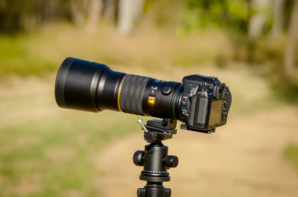 Câmera DSLR com teleobjetiva montada em tripé, simbolizando captura autenticada