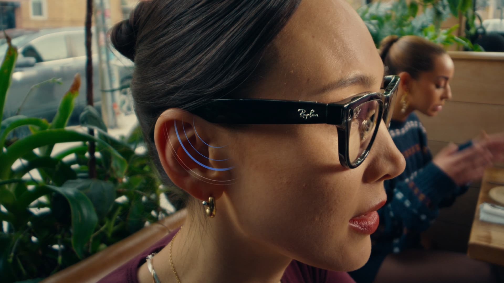 Mulher usando Ray-Ban Meta com Conversation Focus em ambiente movimentado