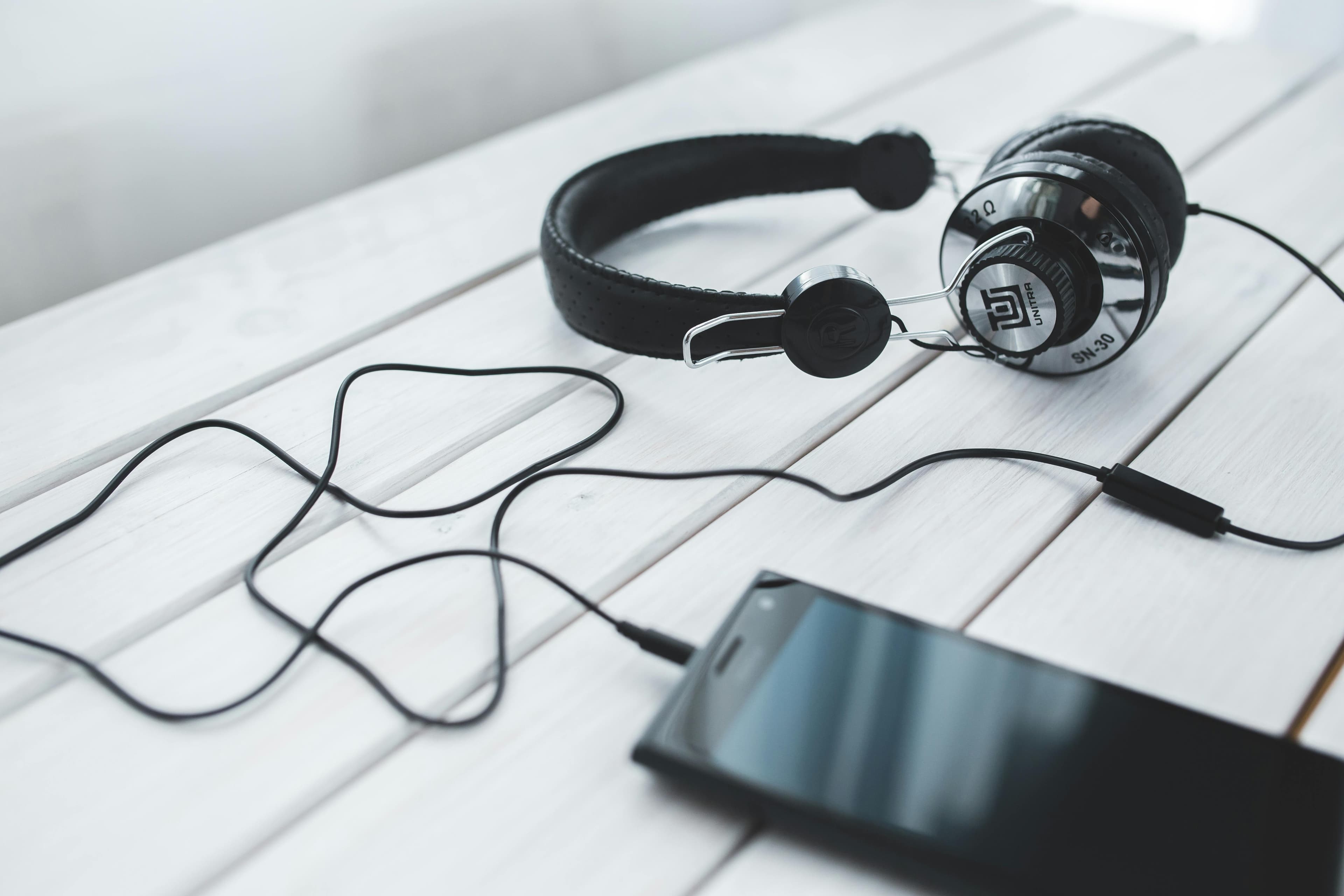 Smartphone conectado a fones de ouvido sobre mesa, simbolizando tradução em tempo real