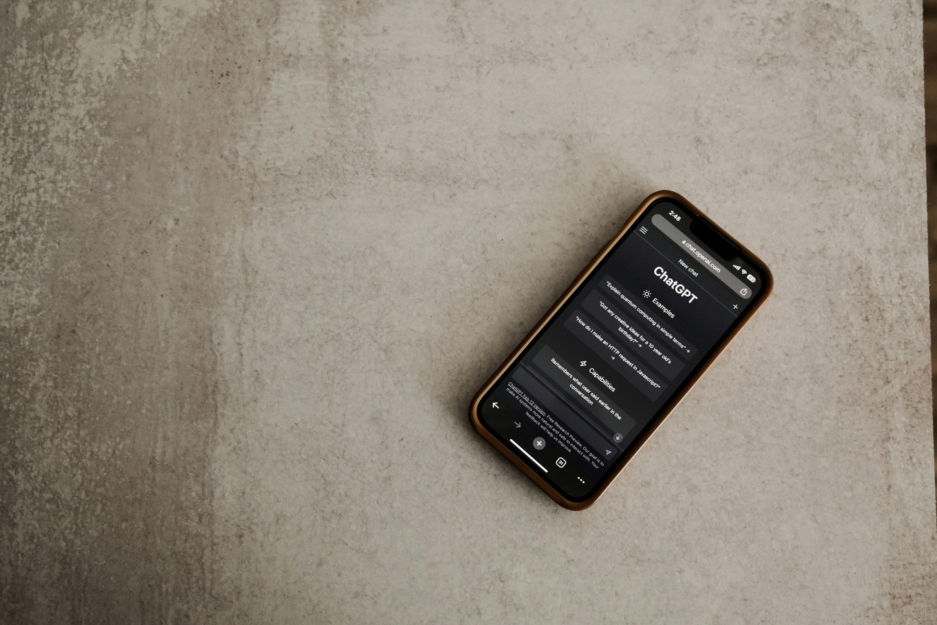 Smartphone exibindo aplicativo de chat de IA em uma mesa, foco em tela