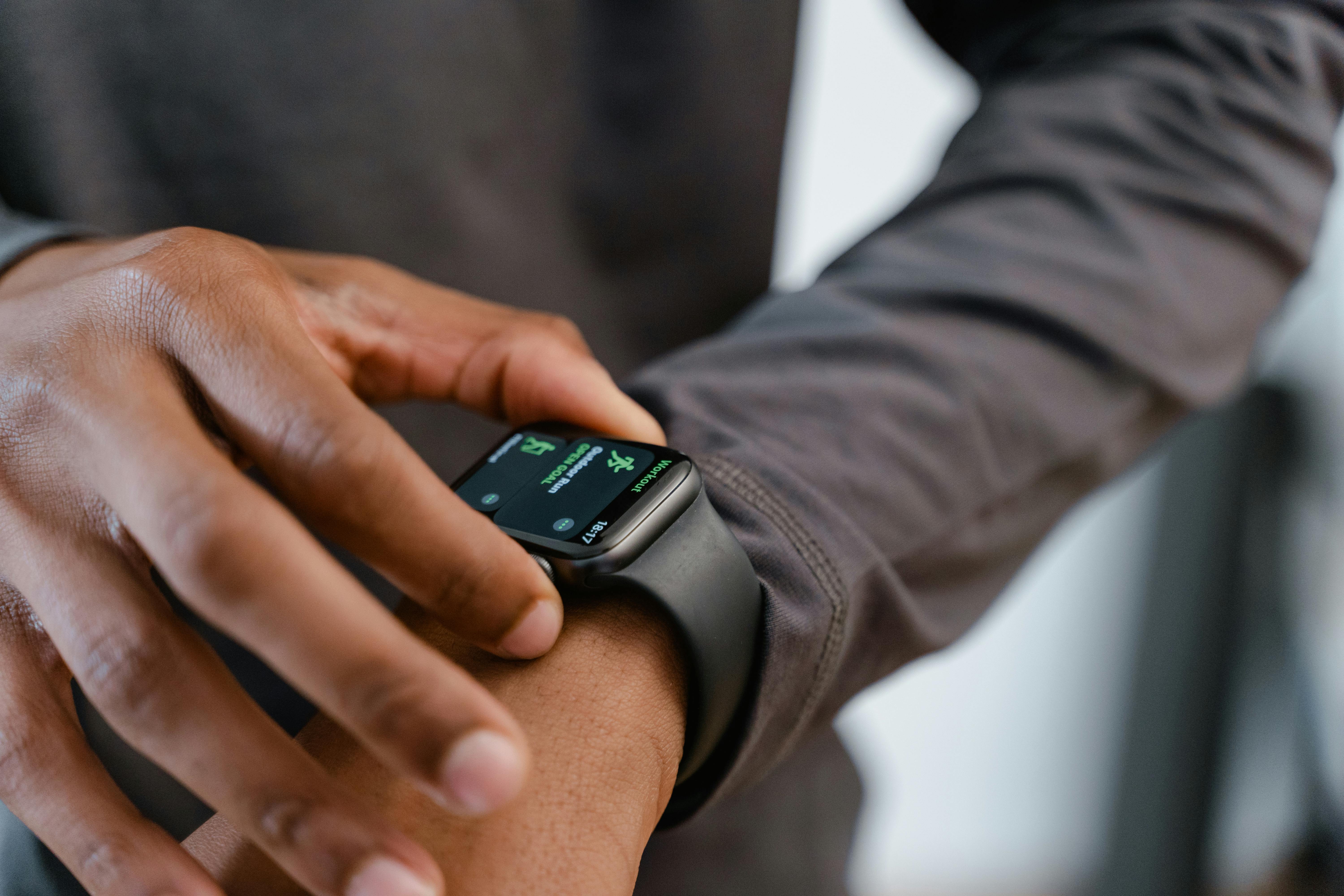 Pessoa ajustando um smartwatch no pulso, foco em tela de fitness