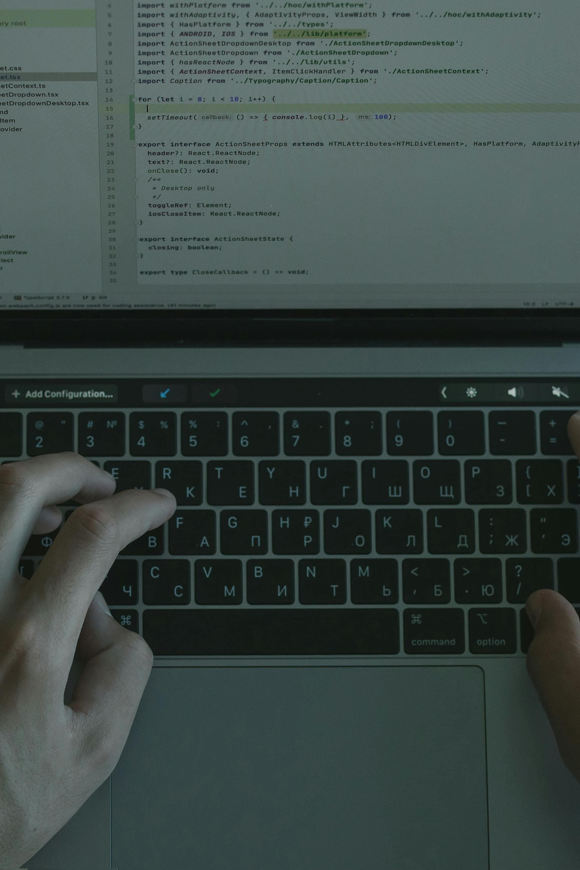 Mãos digitando em laptop com editor de código aberto