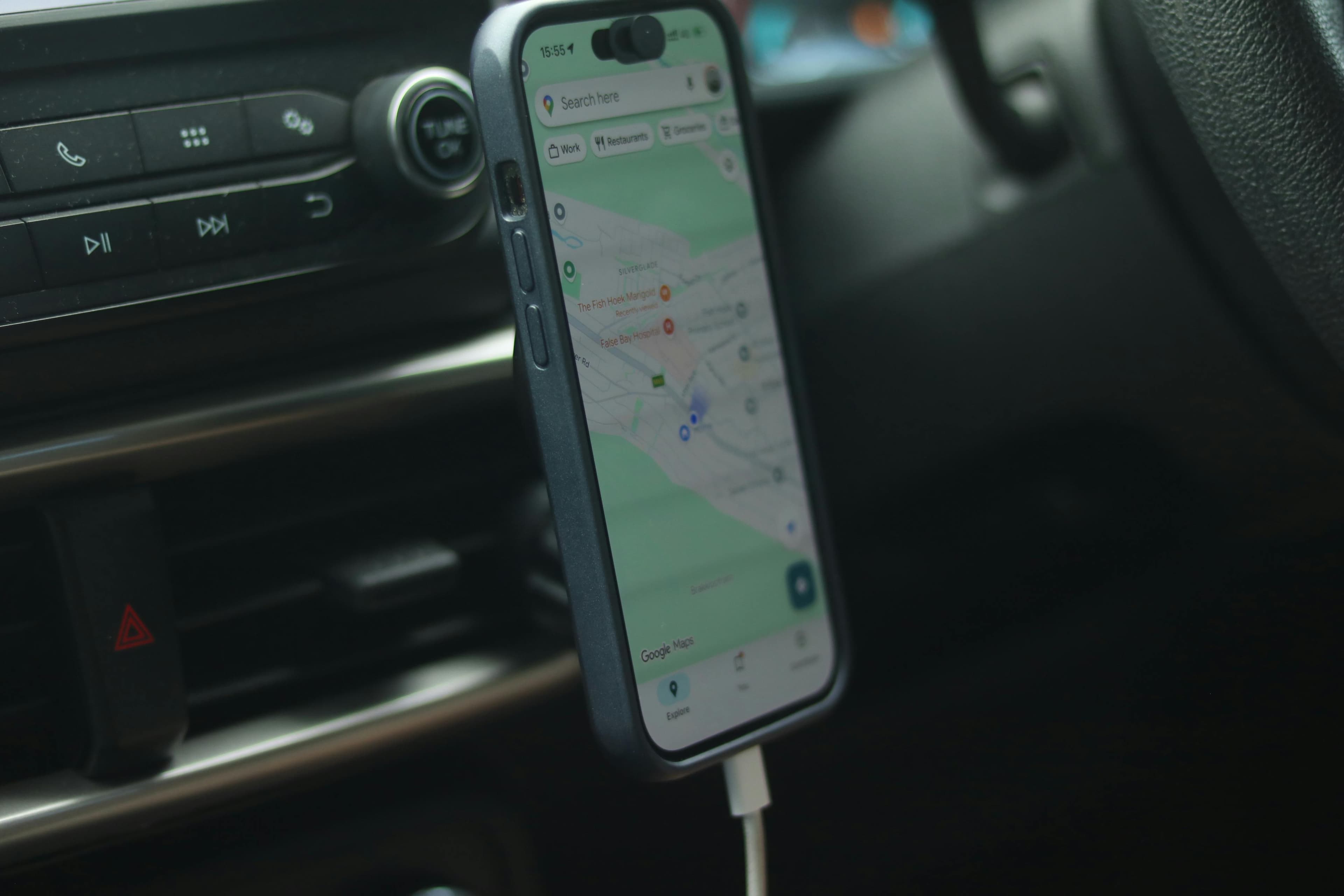 Smartphone com Google Maps exibido no painel do carro, representando navegação com IA