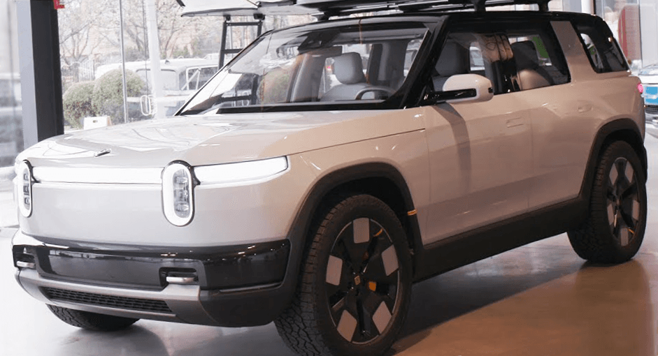 Rivian R2 em exibição com acabamento claro e rodas aero