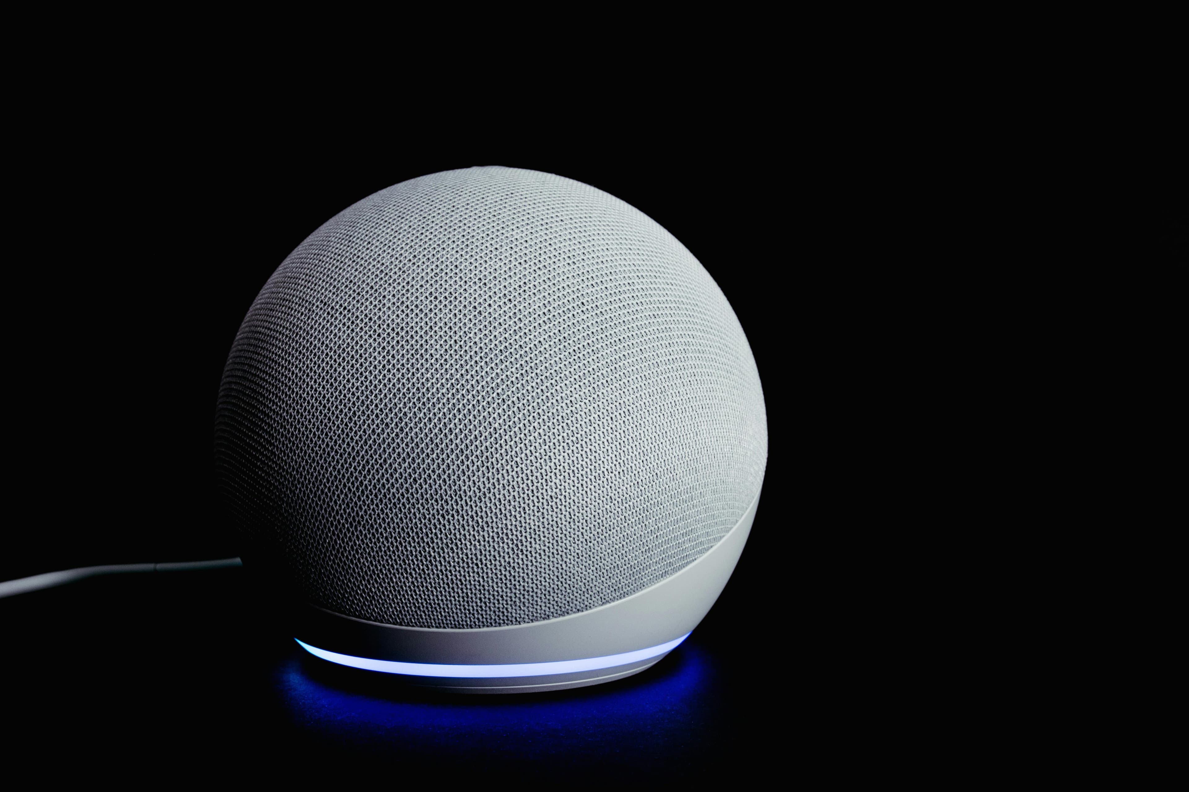 Foto de Echo Dot aceso em fundo escuro, simbolizando Alexa+ com novo estilo de personalidade