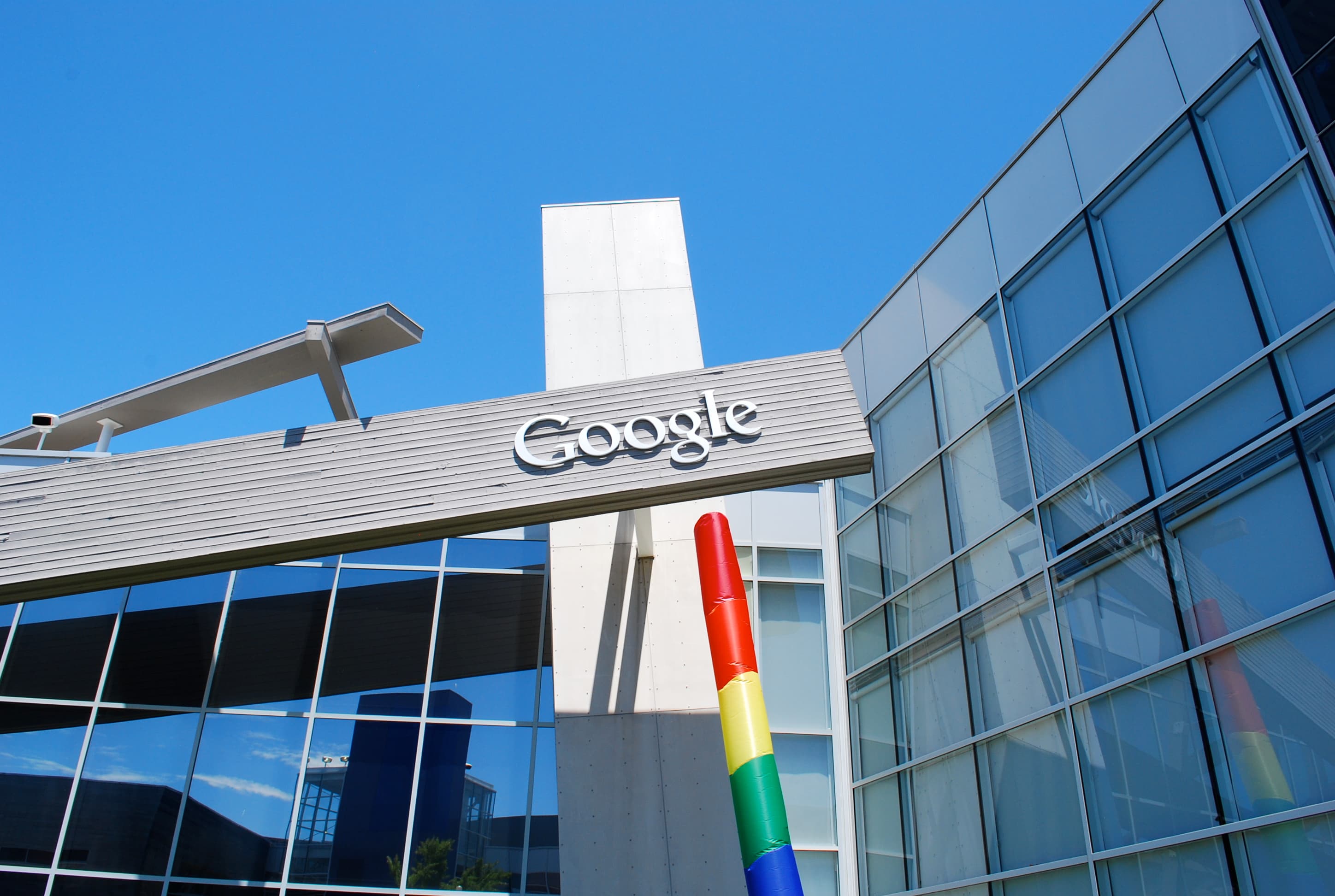 Entrada do Googleplex com o logotipo do Google visível na fachada de vidro