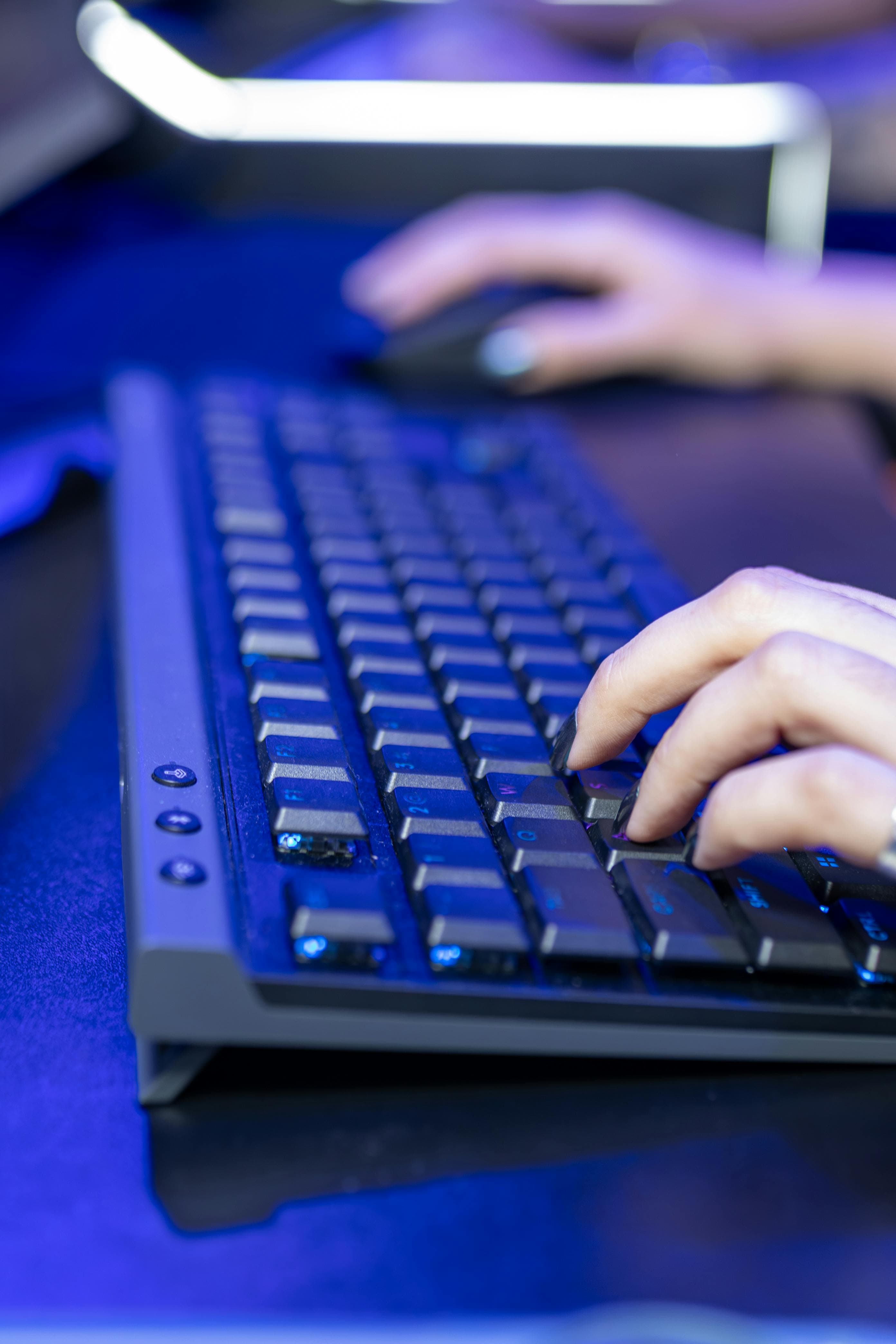 Mãos digitando em teclado com foco em monitoramento de entradas