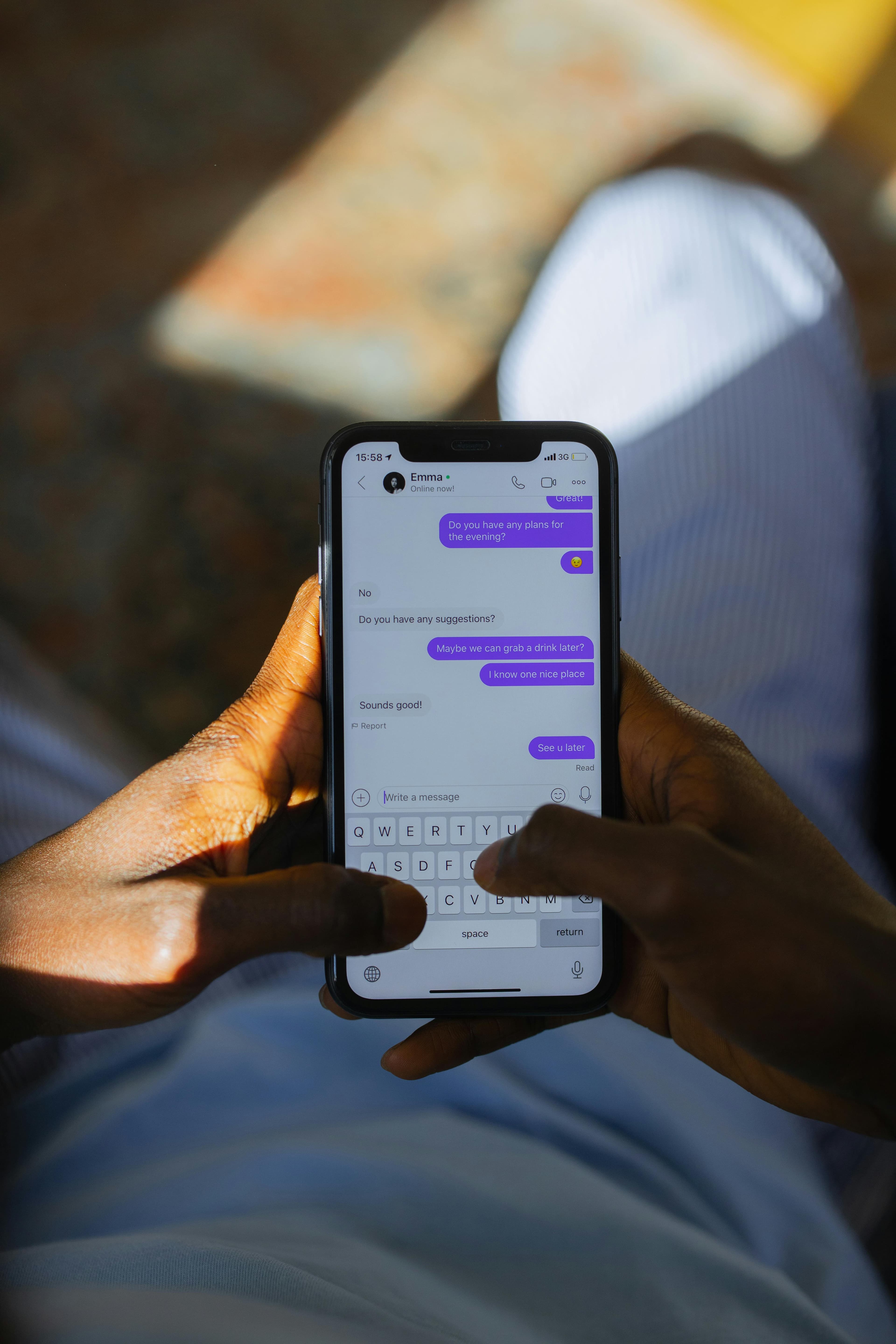 Mãos segurando smartphone com interface de chat visível