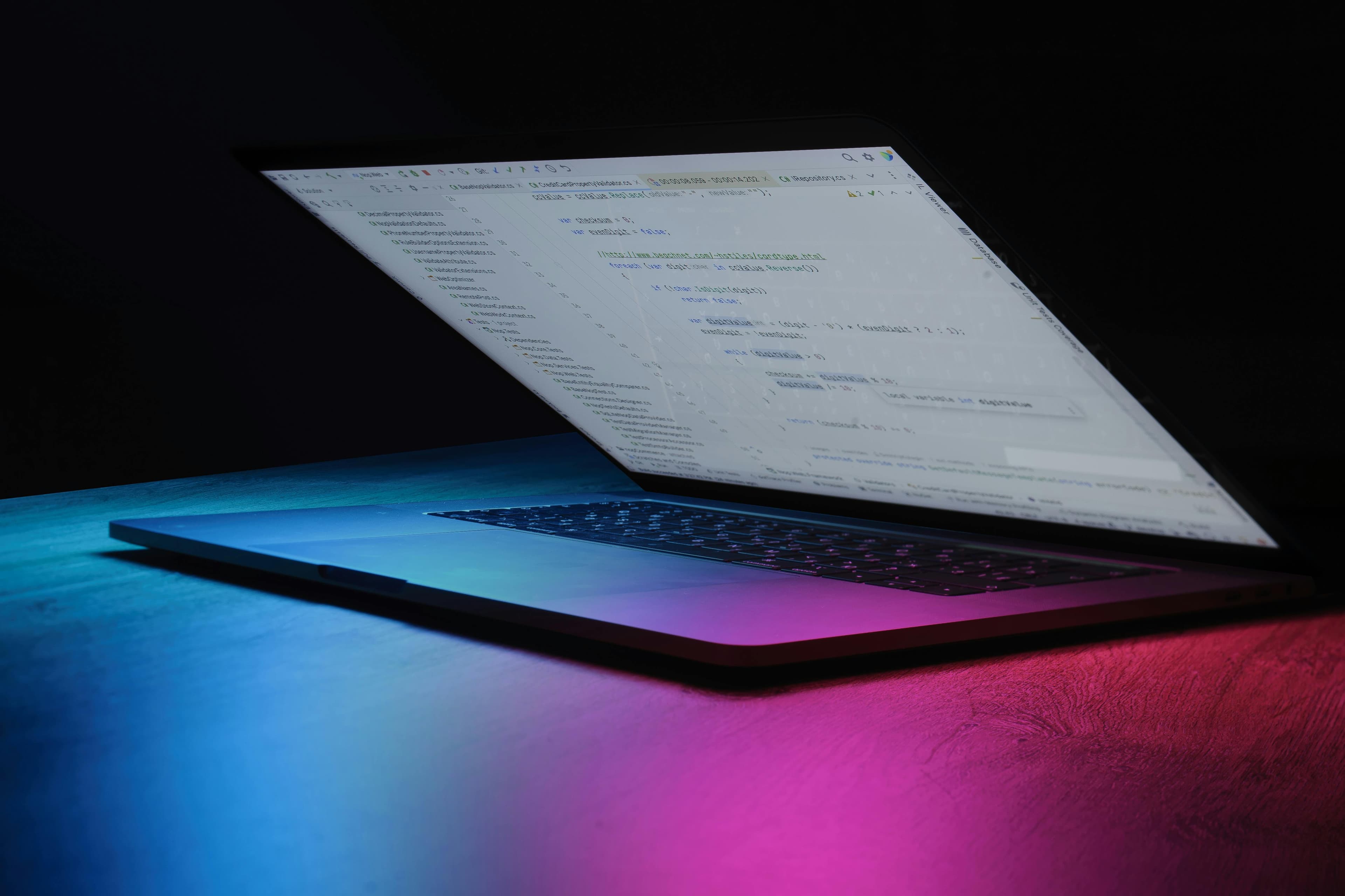Laptop com código e iluminação neon, representando IA
