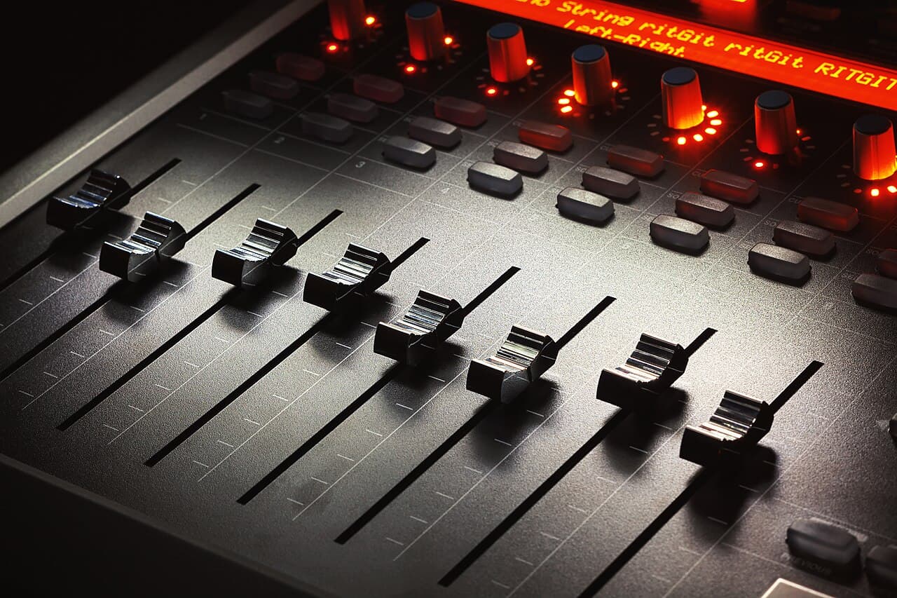 Close em faders de uma mesa de som moderna, simbolizando produção musical com IA