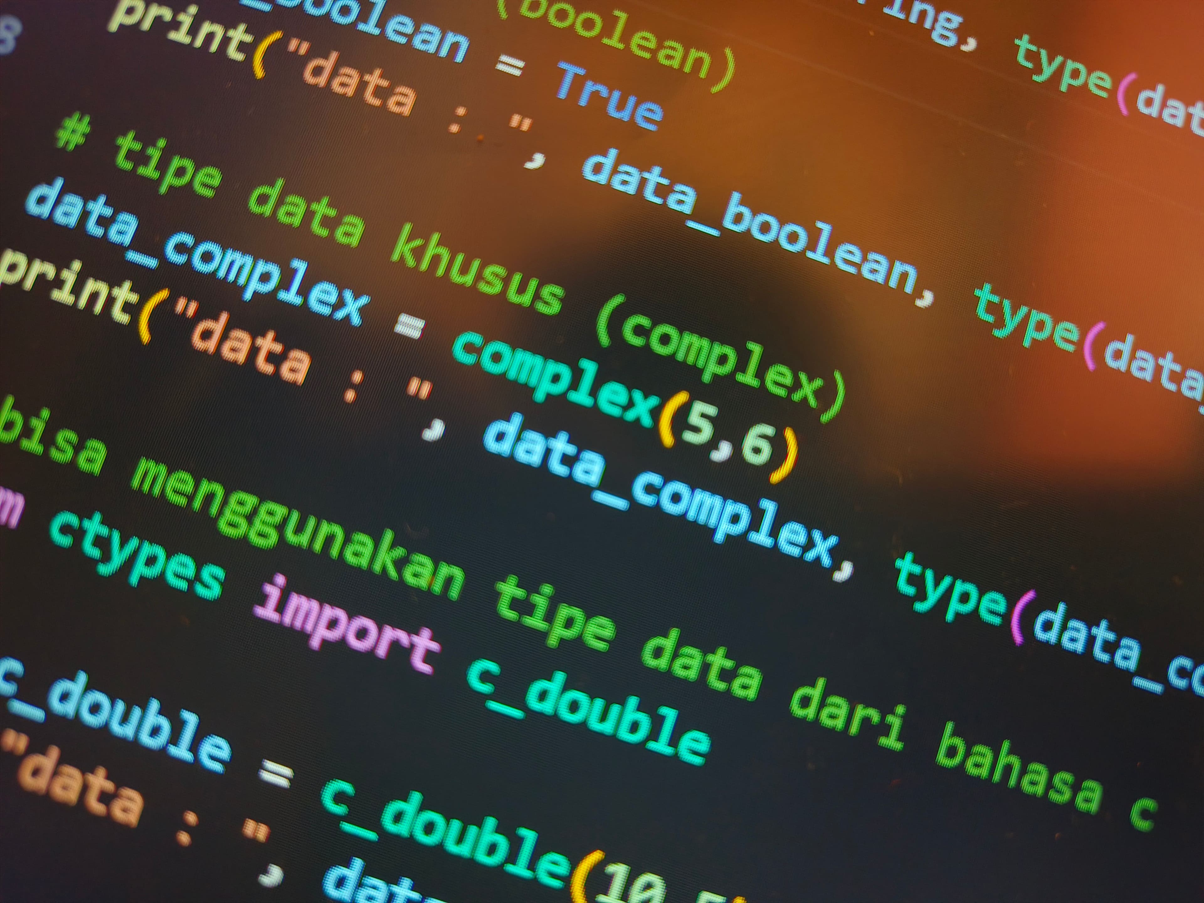 Tela de computador exibindo código colorido em close