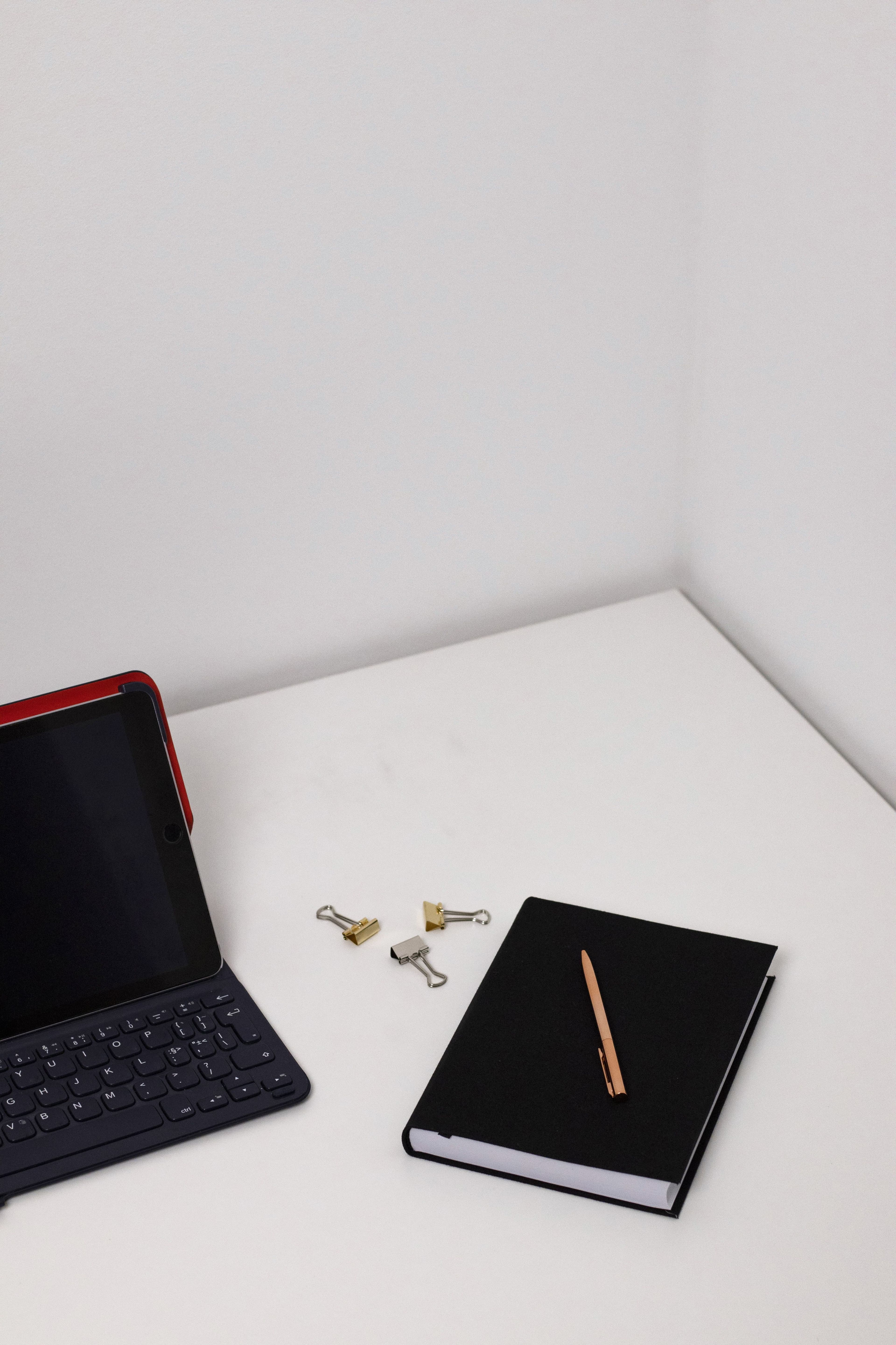 Workspace minimalista com tablet, teclado e caderno representando pesquisa com IA