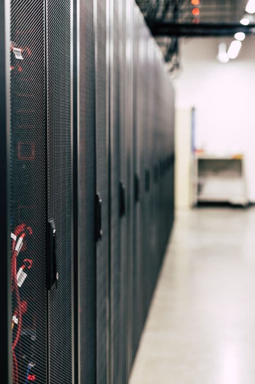 Corredor de racks em datacenter ilustrando infraestrutura de IA