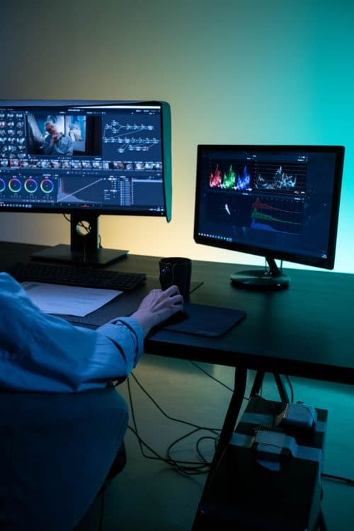 Estação de edição de vídeo com monitores exibindo escopos e interface de color grading