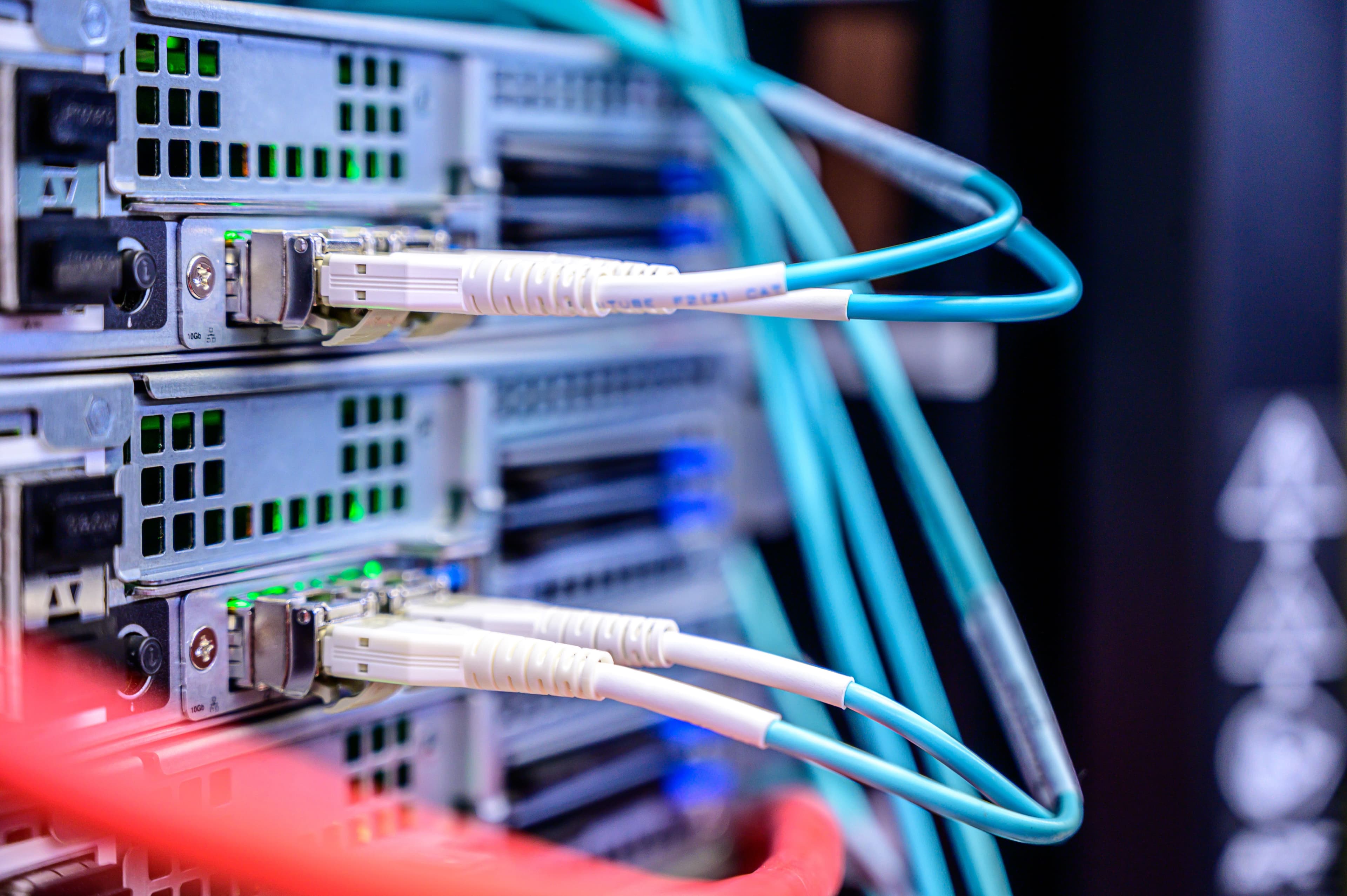Detalhe de cabos Ethernet conectados em um servidor, simbolizando roteamento de modelos de IA