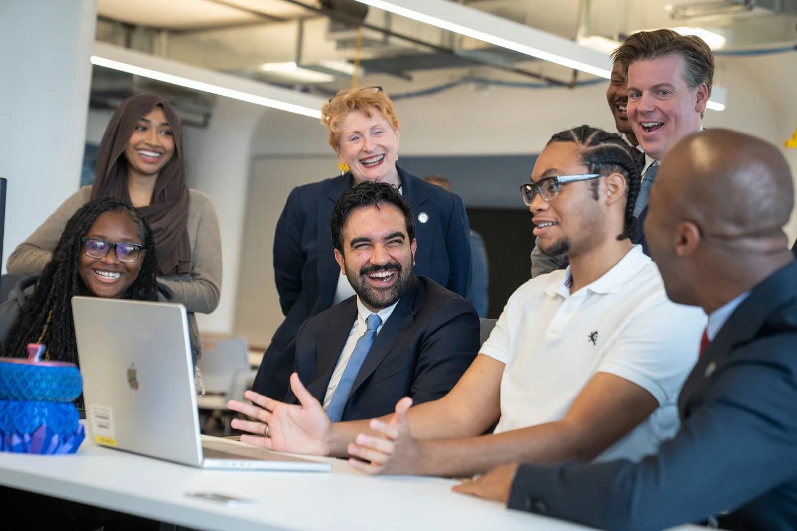Prefeito de NYC, Zohran Mamdani, conversa com estudantes diante de um laptop