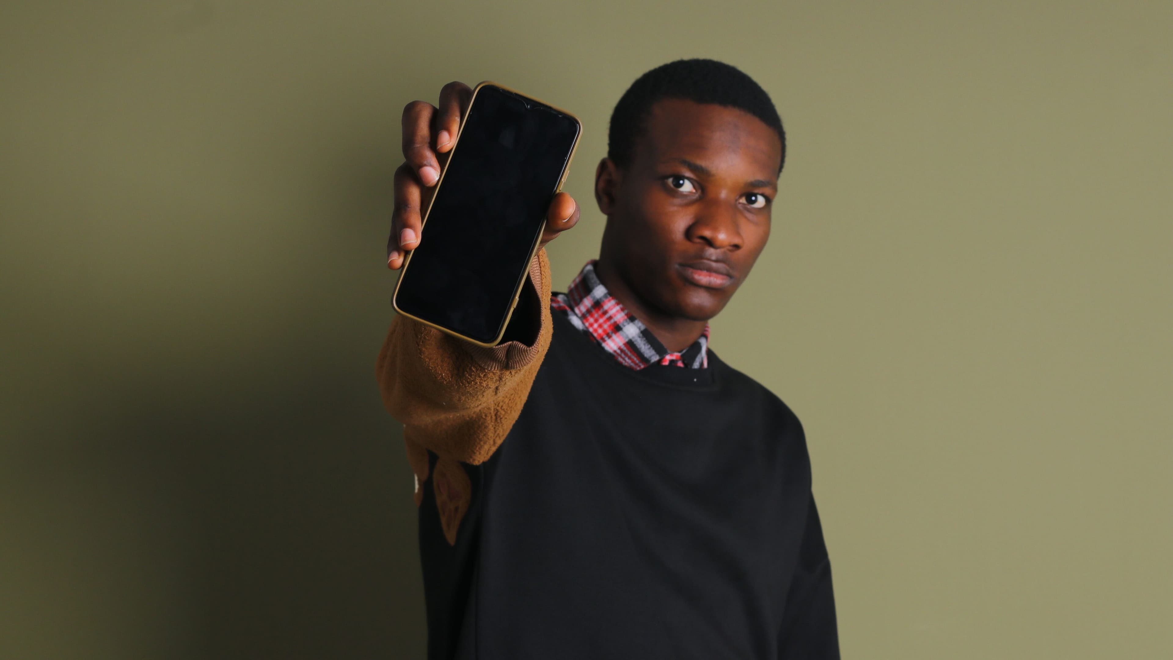 Adolescente segurando smartphone, conceito de uso de IA com foco em segurança