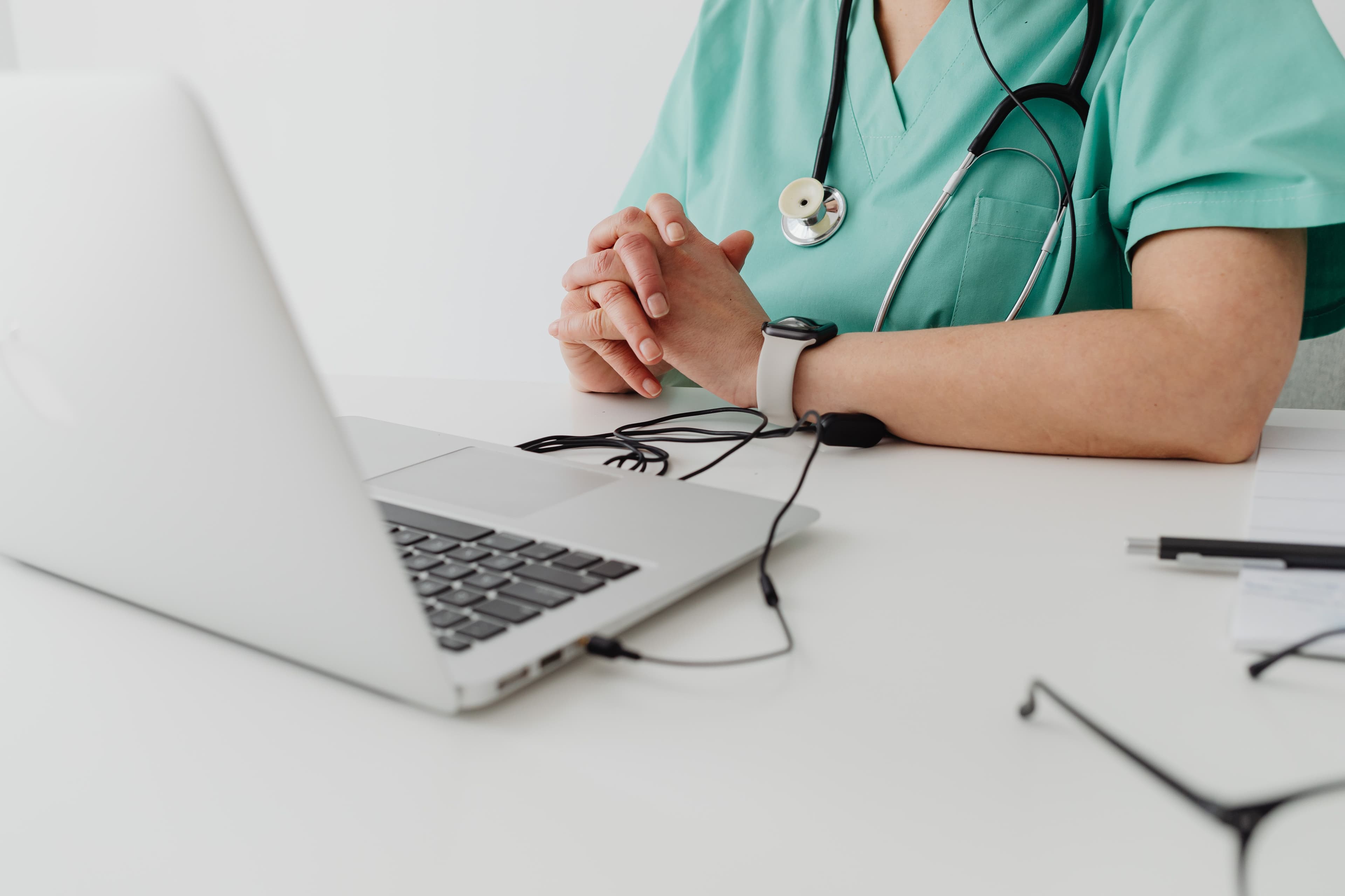 Profissional de saúde usando laptop em ambiente clínico