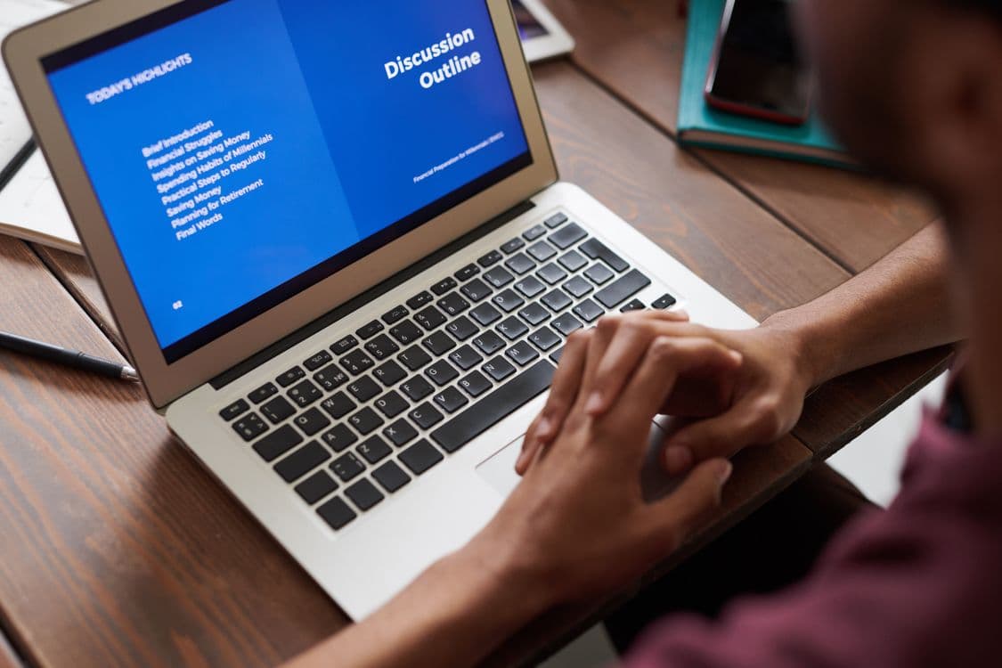 Pessoa vendo uma apresentação em laptop, representando leitura interativa e exportação para PowerPoint