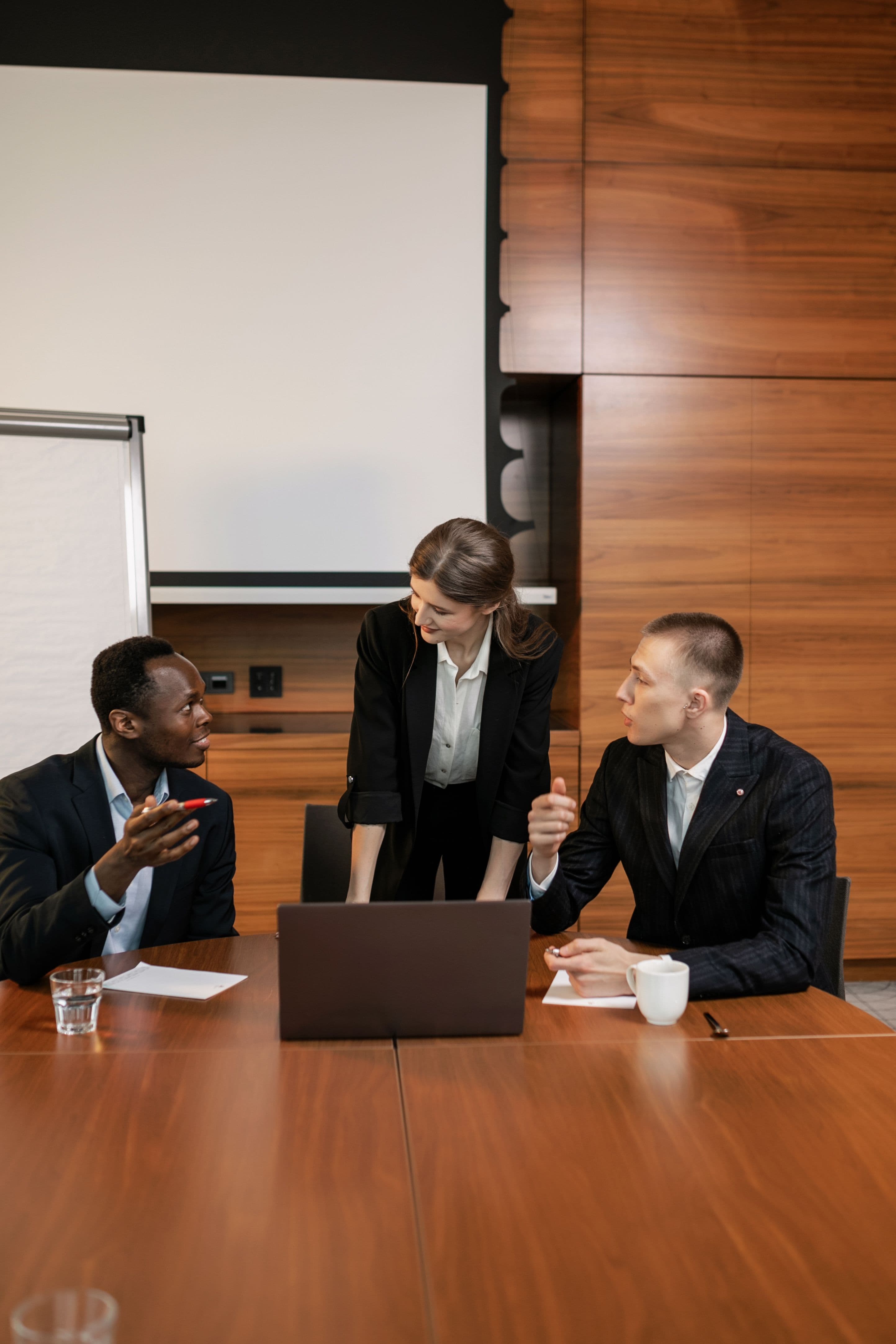 Equipe de vendas em reunião analisando dados e laptop, simbolizando adoção do Claude no fluxo comercial