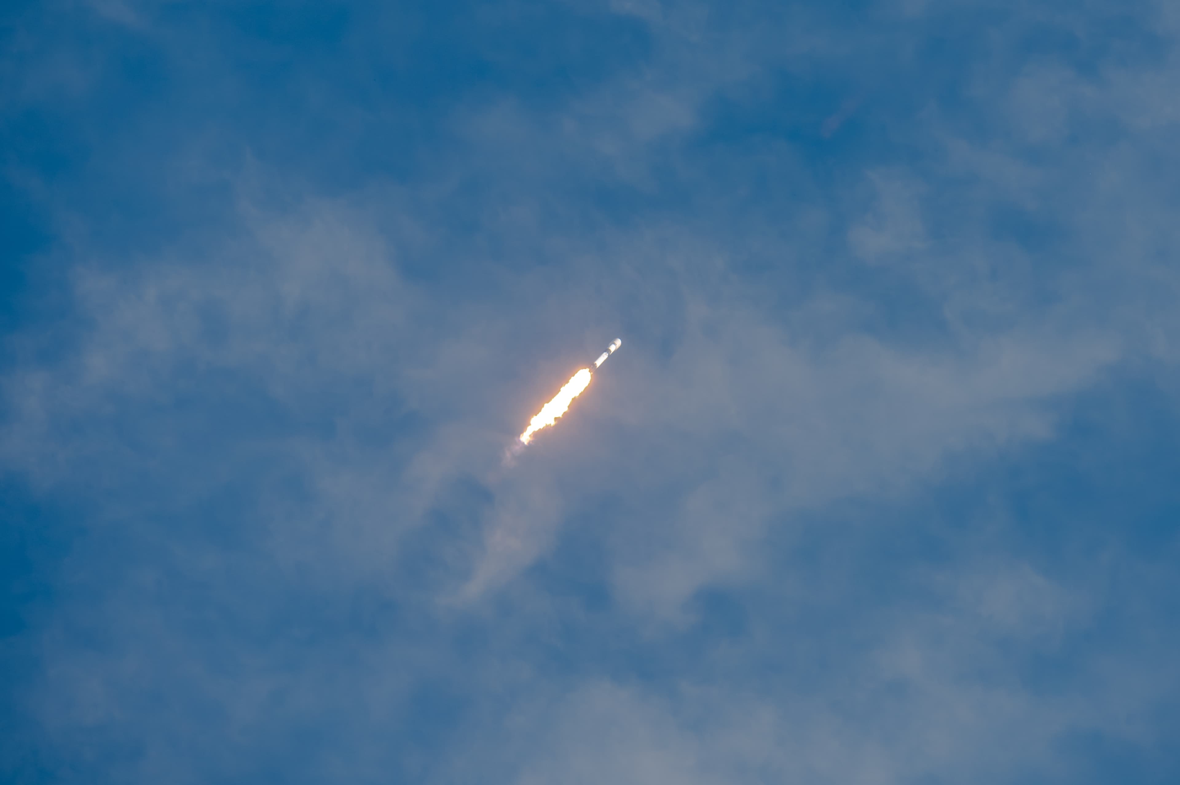 Falcon 9 da SpaceX ascendendo ao céu em lançamento, chamas visíveis do motor