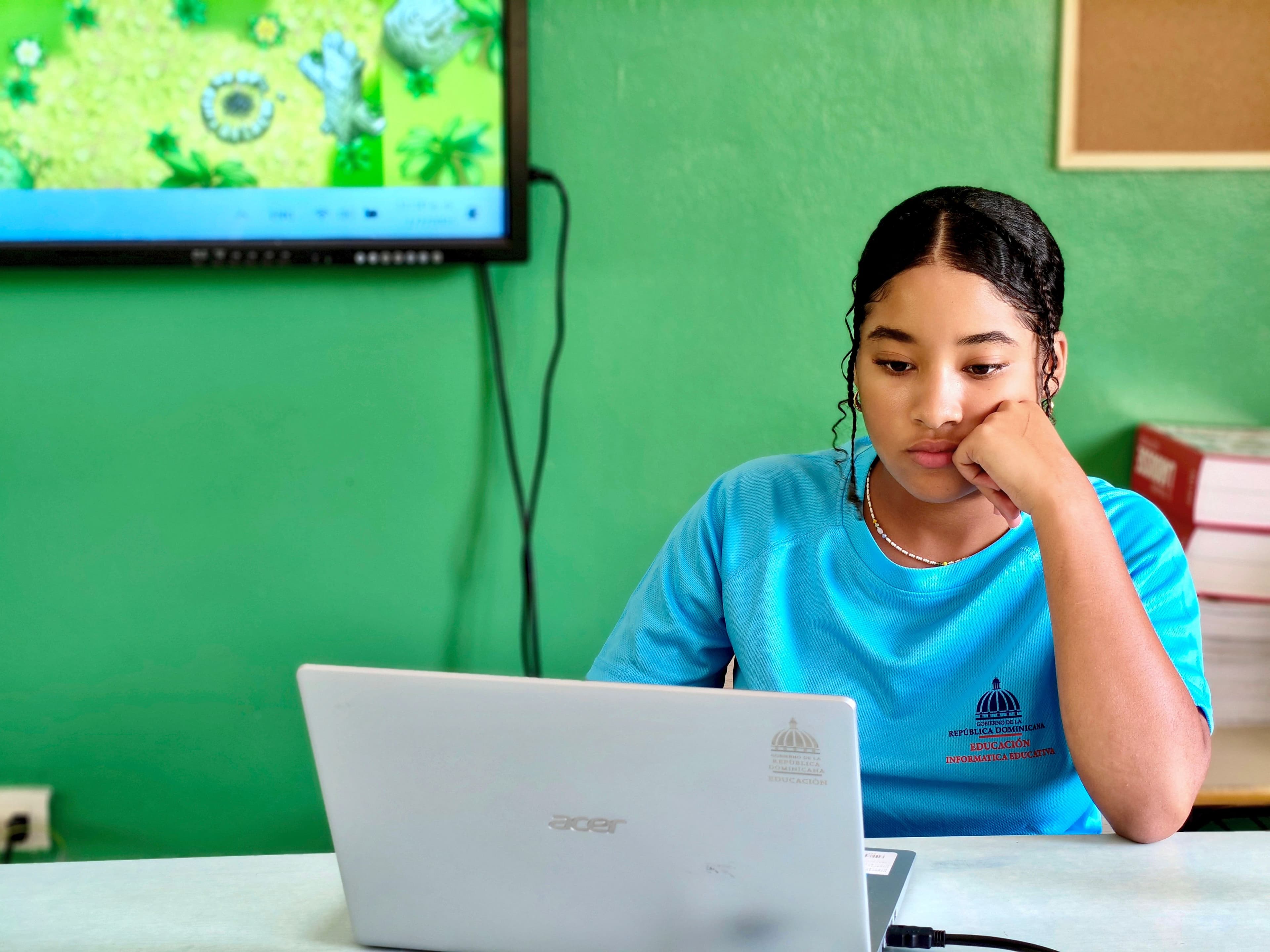 Estudante usando laptop em sala de aula, representando aprendizagem de IA
