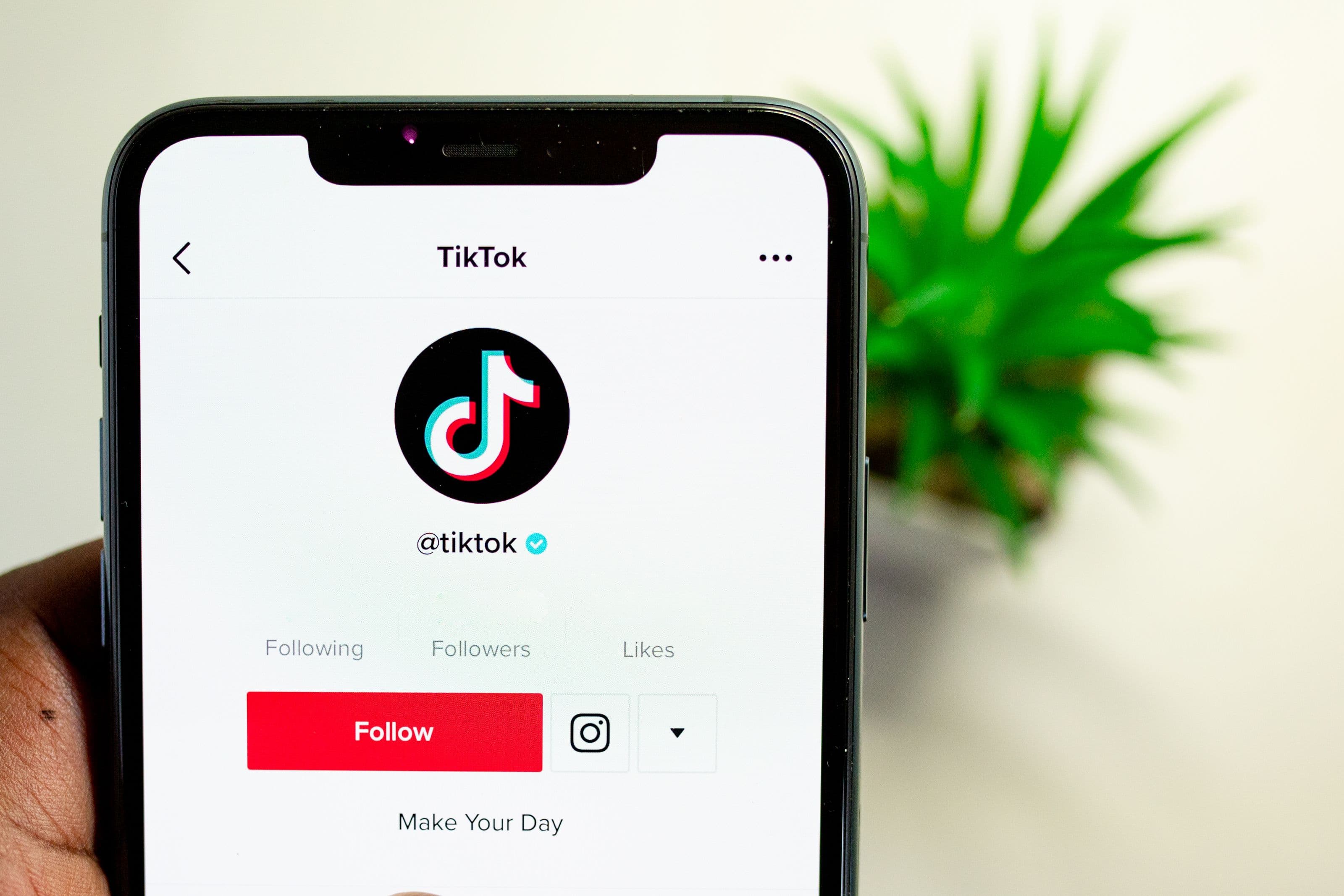 Mão segurando smartphone com o logo do TikTok na tela