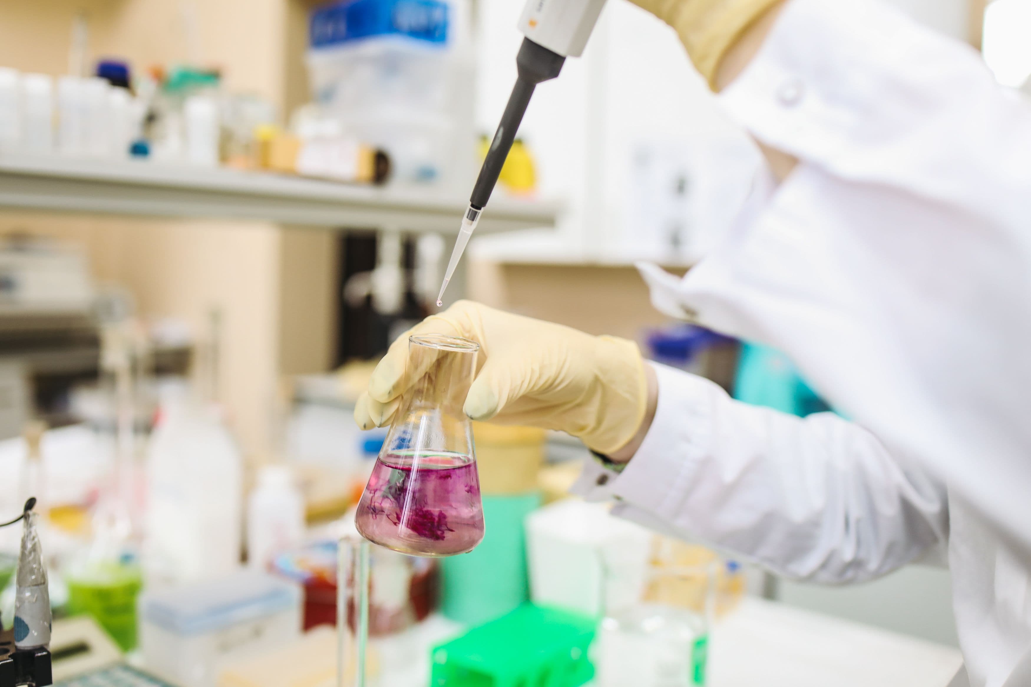 Pesquisador em laboratório manipulando amostra com pipeta
