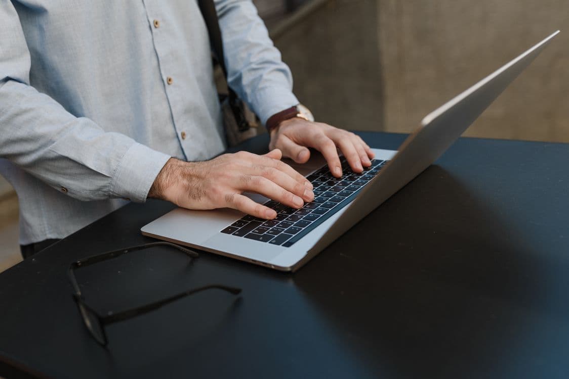 Mãos digitando em laptop, representando agentes de IA em atividade