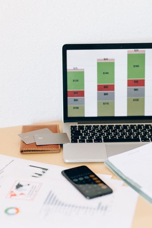 Laptop com gráficos financeiros em destaque, representando análises para PMEs