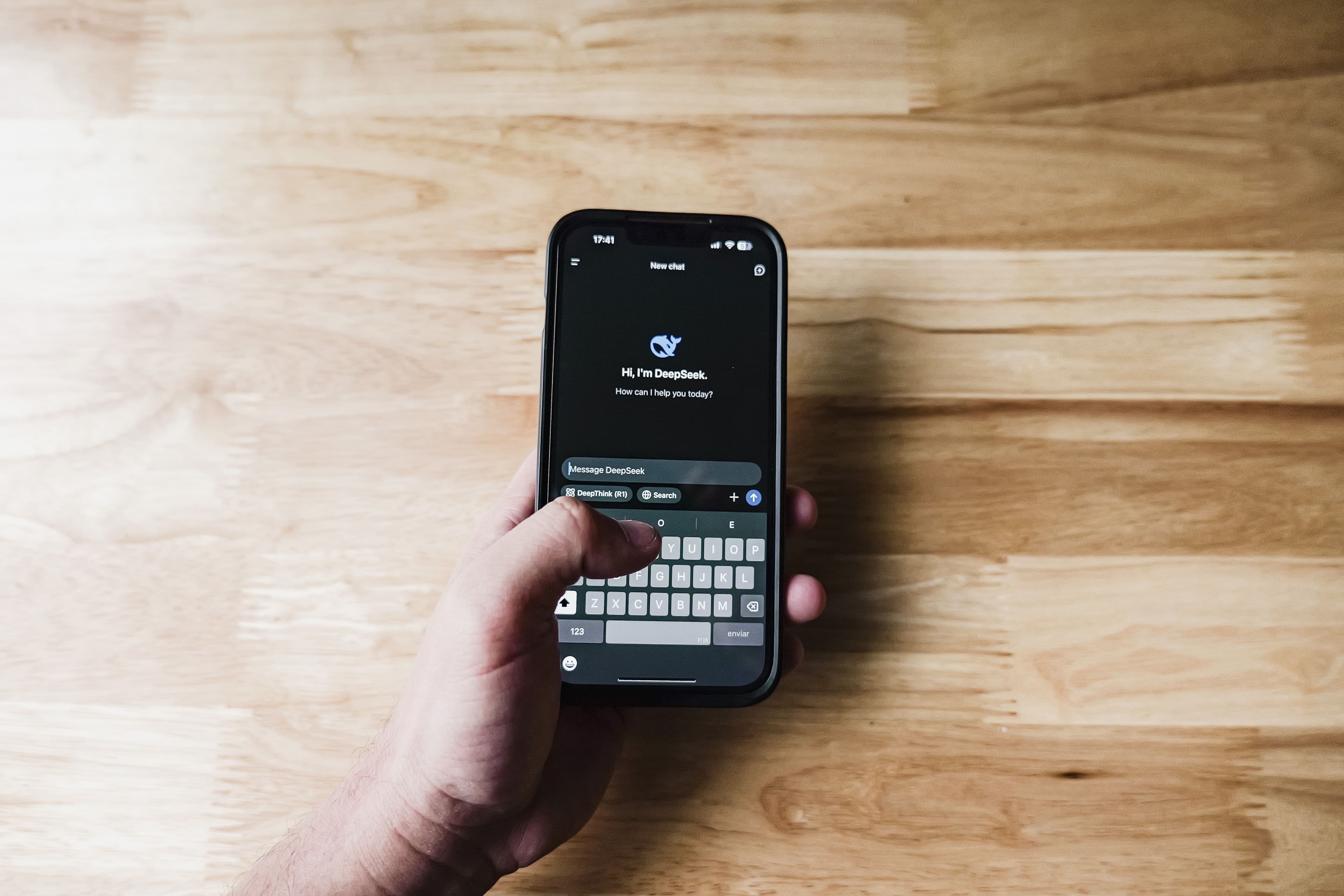 Mão segurando smartphone com interface de assistente de IA