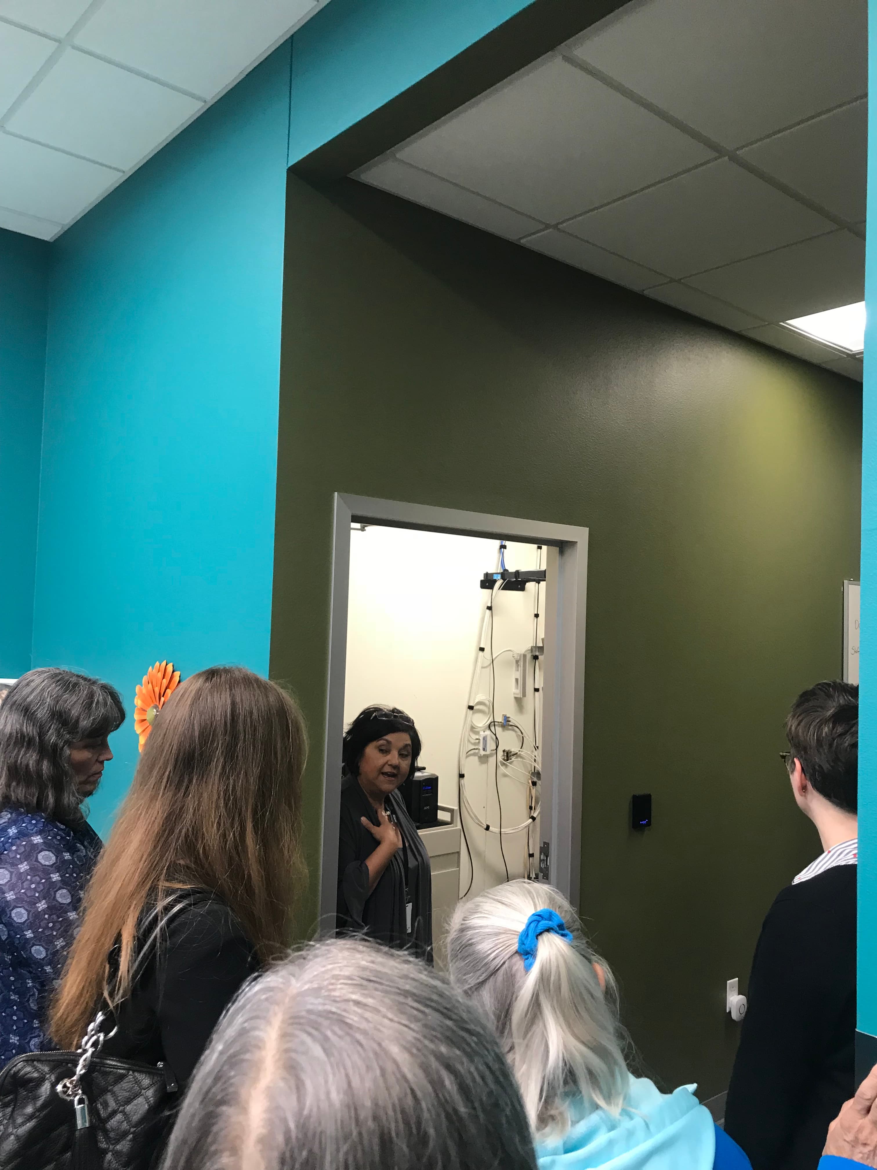 Visão de um corredor de servidores e pessoas em visita a um data center