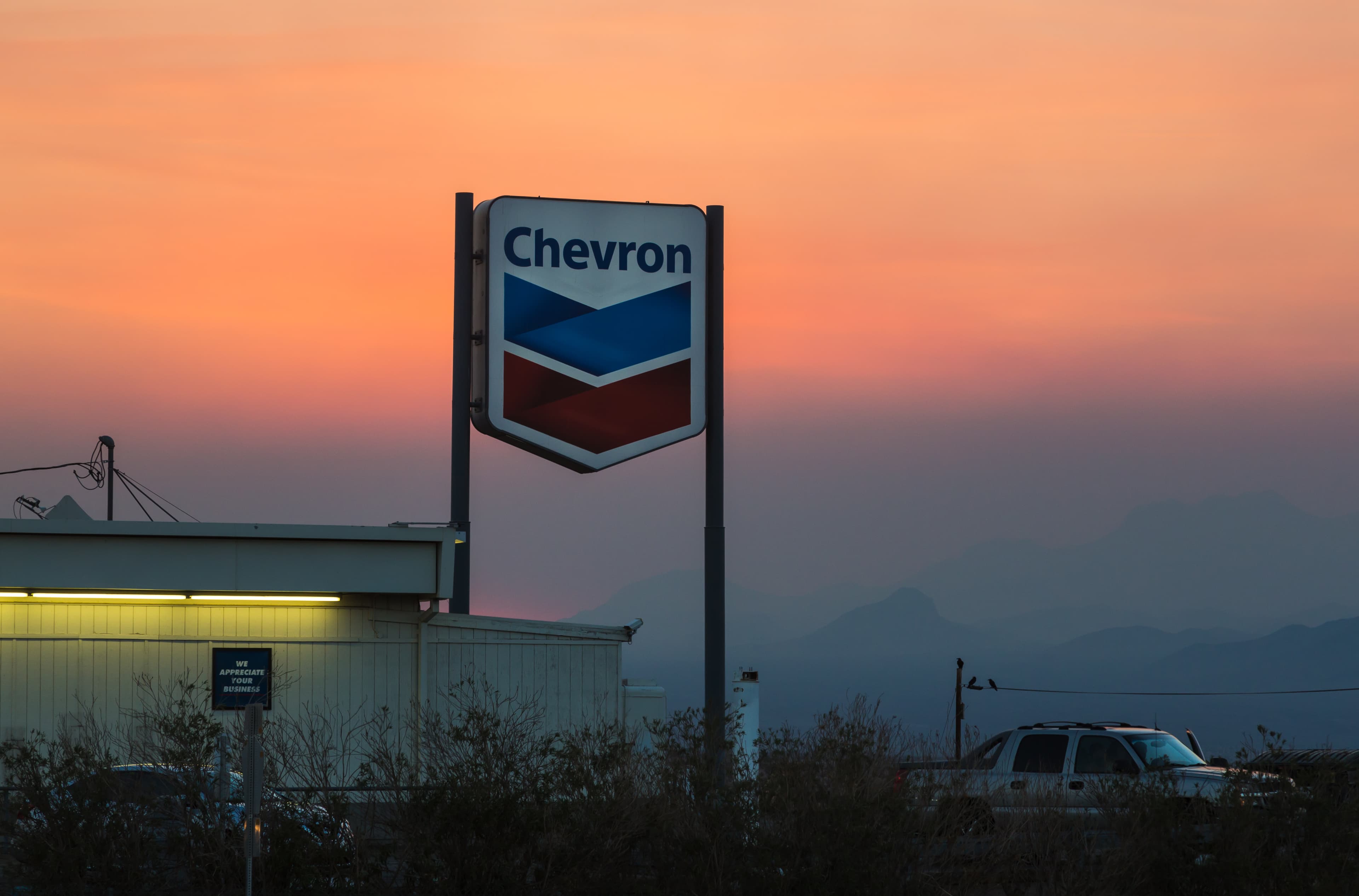 Placa de posto Chevron ao pôr do sol em Ludlow, Califórnia